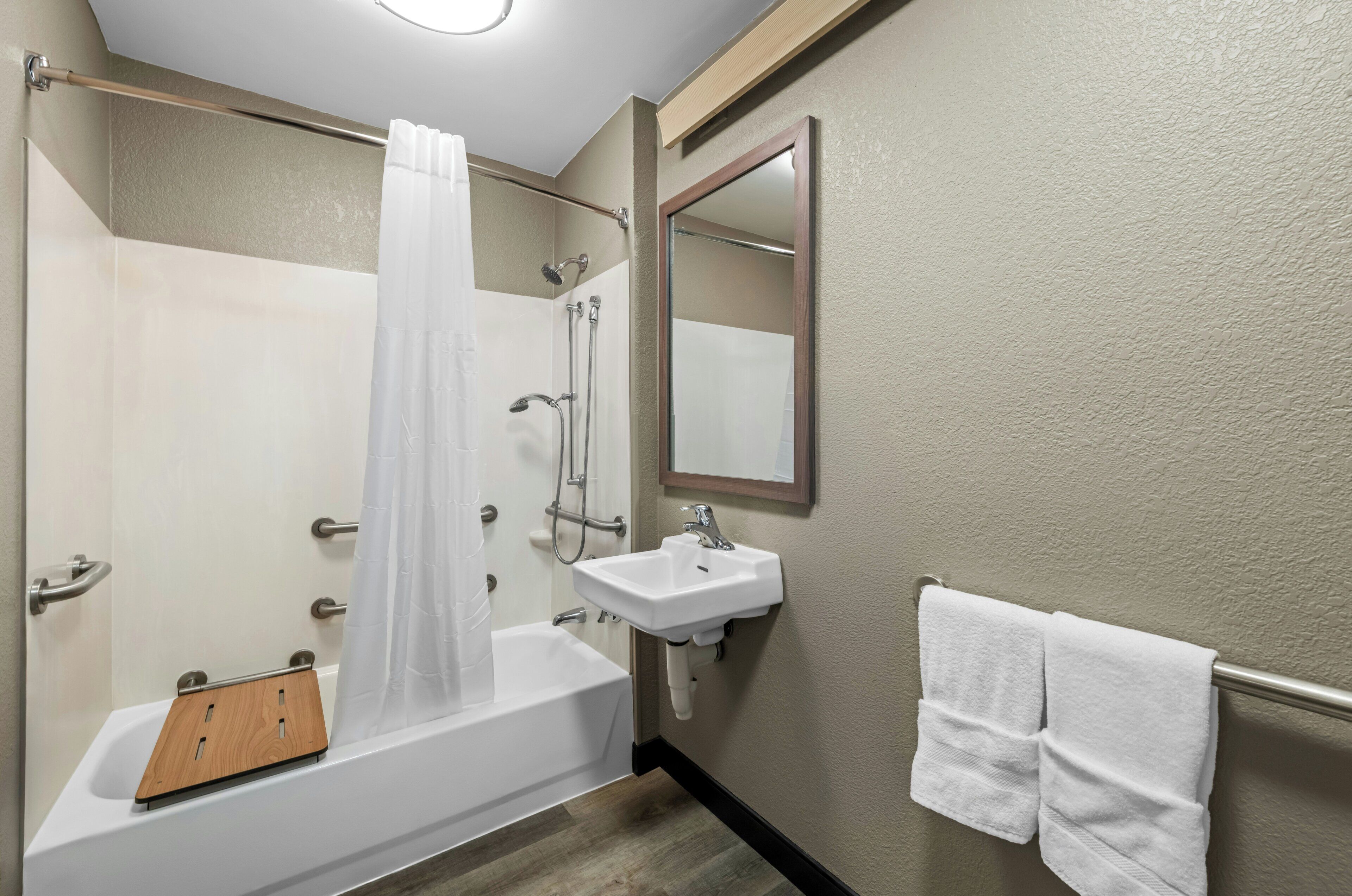 A bathroom with a bathtub, shower, and sink.