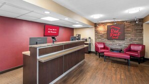 A Red Roof Inn reception area with a Lenovo computer, a coffee machine, and a sign indicating free Wi-Fi in all rooms. - Red Roof Inn Asheville - Biltmore West (Asheville)