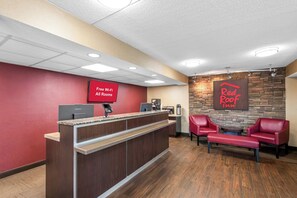 A Red Roof Inn reception area with a Lenovo computer, a coffee machine, and a sign indicating free Wi-Fi in all rooms. - Red Roof Inn Asheville - Biltmore West (Asheville)