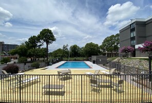 Una piscina al aire libre de temporada, sombrillas