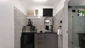 A compact kitchen with a dishwasher, microwave, and a small sink. - Alabaster Motor Inn Taree (Taree)