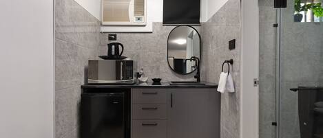 A compact kitchen with a dishwasher, microwave, and a small sink.