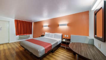 Une chambre d’hôtel avec un lit, un bureau et une chaise.