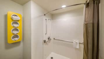 A shower with a grab bar, a towel rack with towels, and a yellow towel holder.