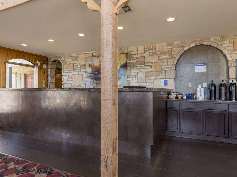 A reception area with a stone wall, wooden reception desk, and a framed certificate on the wall.