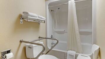 A bathroom with a toilet, a shower, and a grab bar.