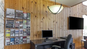 Ett rum med träpanel på väggarna, ett skrivbord, en dator och en stol.