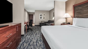 Ein Hotelzimmer mit einem Bett, einem Fernseher, einem Schreibtisch, einem Stuhl und einer Lampe.