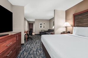 Une chambre d’hôtel équipée d’un lit, d’une télévision, d’un bureau, d’une chaise et d’une lampe.