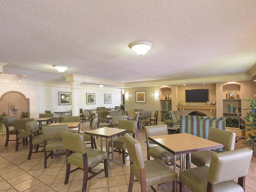 A hotel lobby with multiple seating areas, a fireplace, and a television.