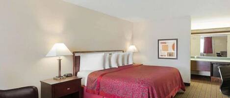 A hotel room with a bed, bedside lamps, a desk, a chair, and a mirror.
