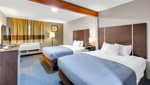 A hotel room with two beds, a desk, a lamp, and a window with curtains. - Quality Inn Salisbury North (Salisbury)