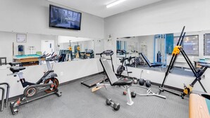 A gym with exercise equipment, a television, and a mirror. - Quality Inn Salisbury North (Salisbury)