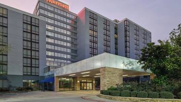 Un hotel Marriott con una fachada moderna, ventanas amplias y una entrada bien iluminada.