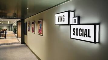 Um corredor com quadros nas paredes e uma placa que diz 'YING in SOCIAL'.