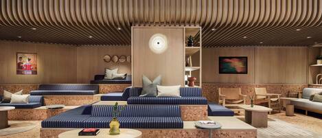 A modern lounge area with tiered seating, a central coffee table, and a decorative wall piece.