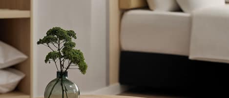 A round wooden table with a book and a vase of green plants.