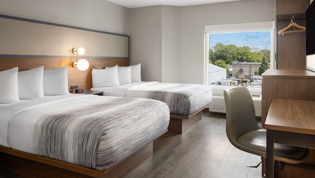 Una habitación de hotel moderna con dos camas, un escritorio y una silla.