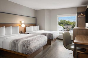 Quarto de hotel moderno com duas camas, uma escrivaninha e uma cadeira.