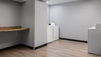Una habitación con piso de madera, un armario blanco y una pared blanca.