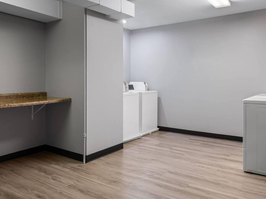 A room with a wooden floor, a white cabinet, and a white wall.