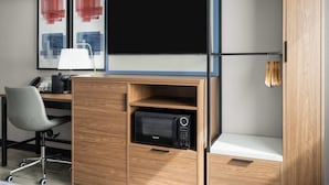 Un espacio de trabajo compacto con escritorio, silla y microondas.