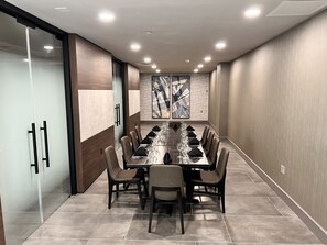 A conference room with a long table, chairs, and a glass partition. - Doubletree by Hilton Bloomington - Minneapolis South (Bloomington)