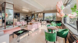 A spacious lounge area with seating, a coffee table, and a large window offering a view of the outdoors. - Antony Hotel (Mestre)
