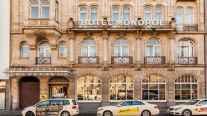 A historic building with a classic facade, multiple balconies, and a prominent entrance with a sign.