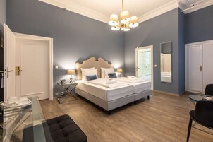 Una camera da letto con un ampio letto, comodini, un lampadario e uno specchio.