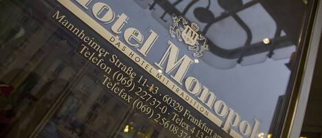 A hotel sign with the name "Hotel Monopol" and contact information.