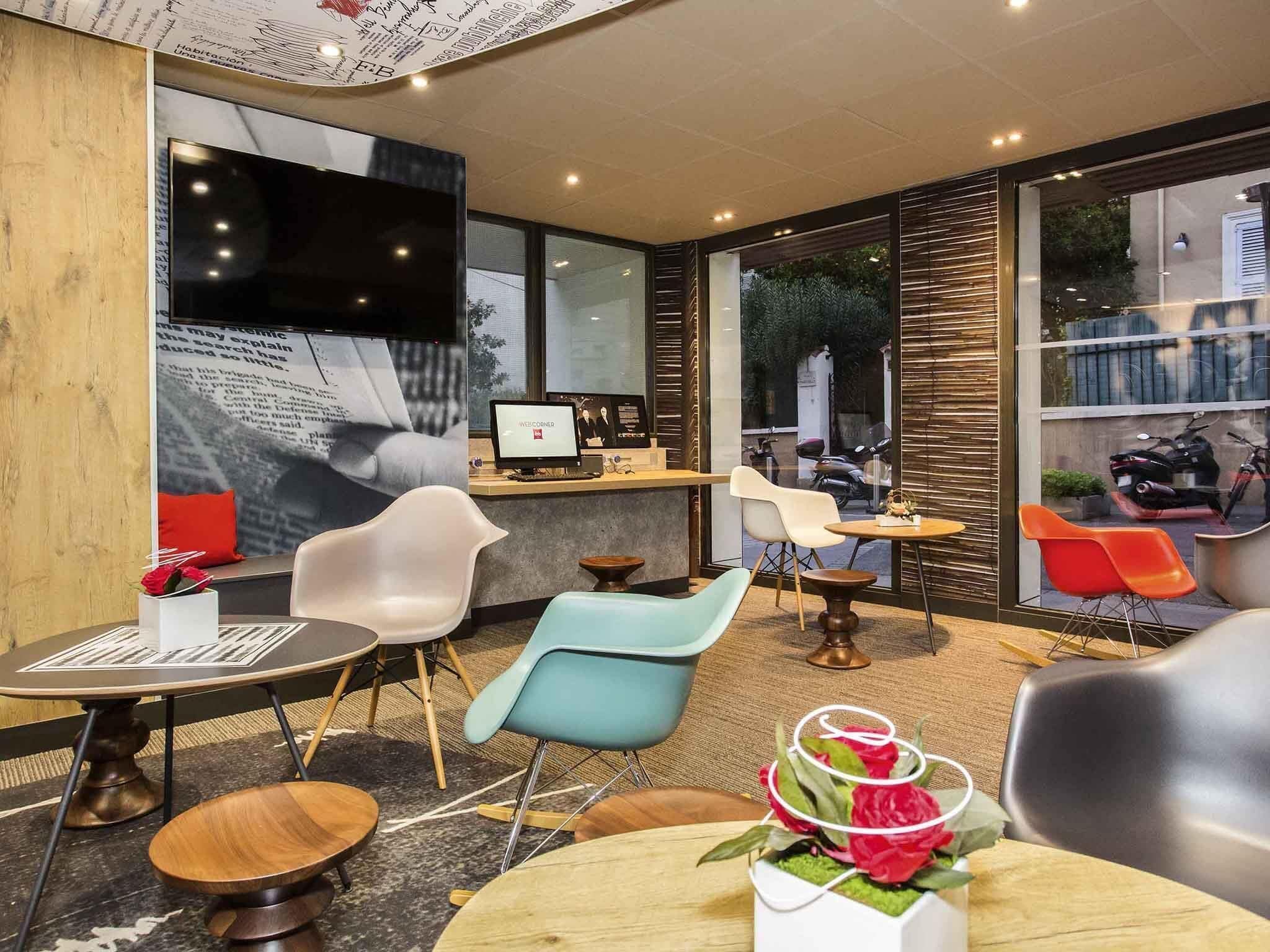 Un intérieur moderne comprenant un comptoir d’accueil, un espace détente et de grandes fenêtres.