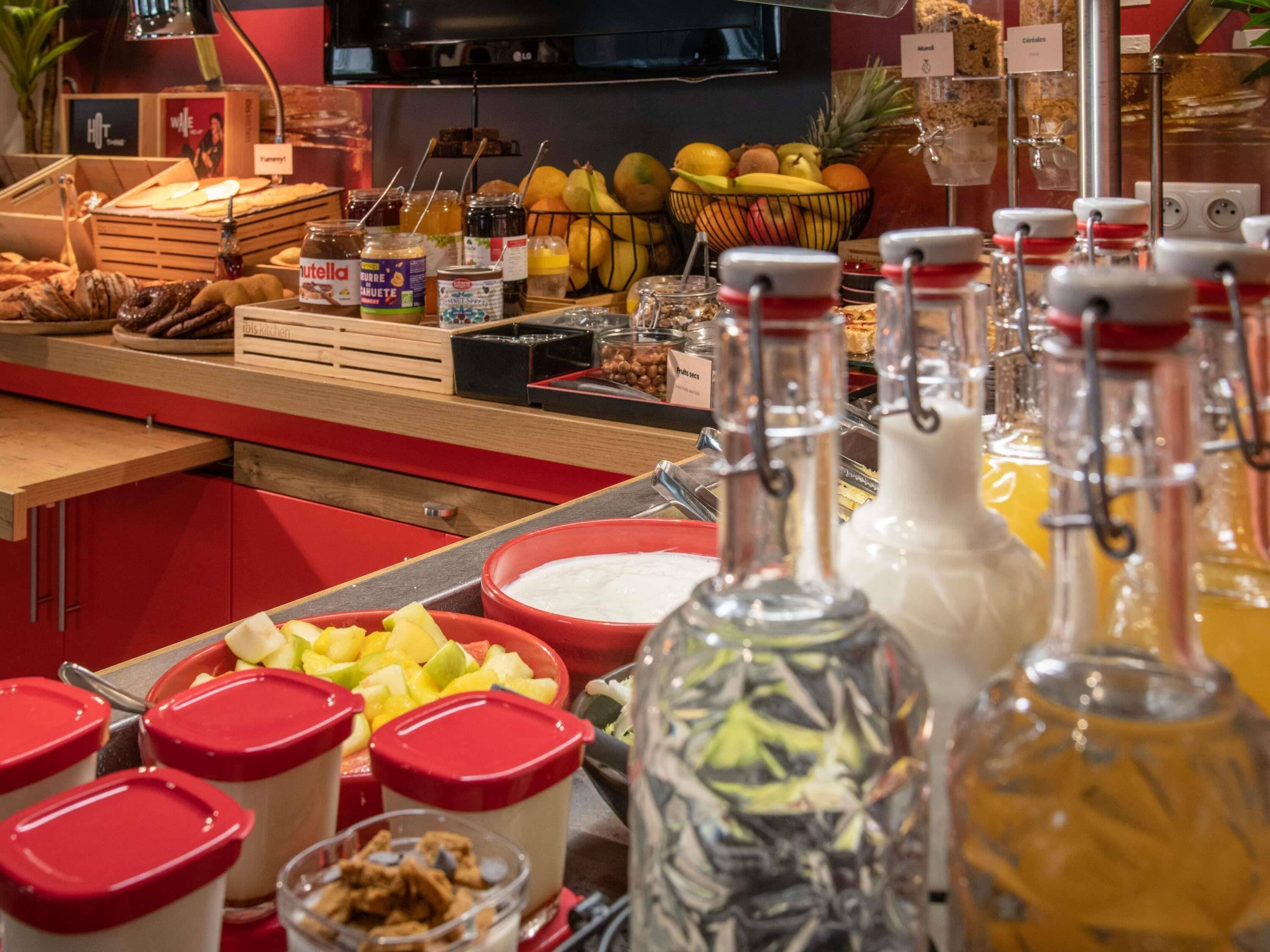 A buffet with various food items, including fruits, condiments, and beverages.