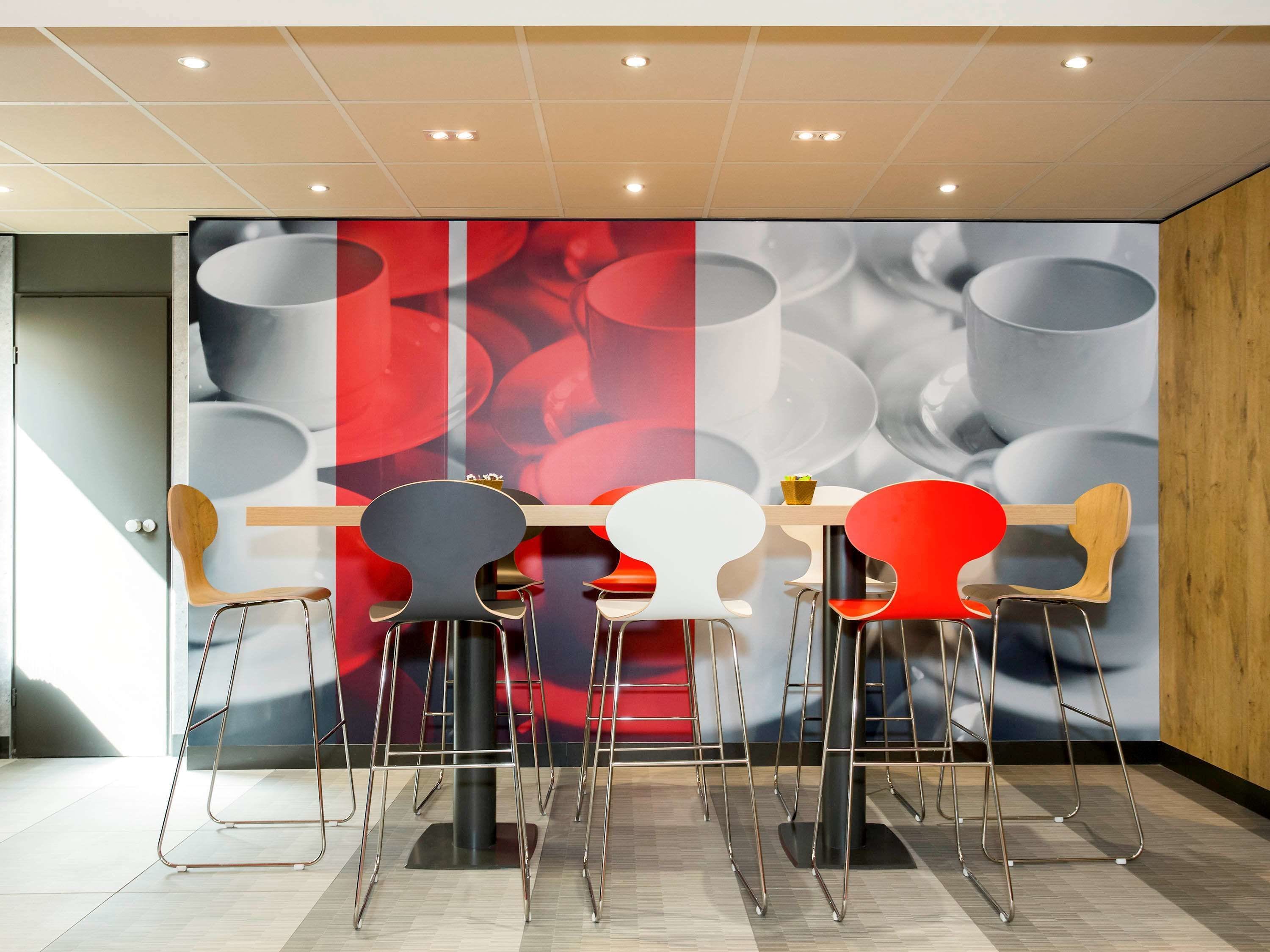Un espace repas moderne avec une table centrale et quatre chaises, chacune ayant un design unique.