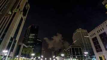 A nighttime cityscape with modern buildings, streetlights, and a clear sky.