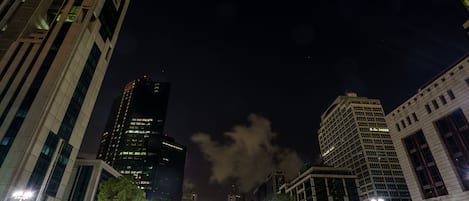 Un paisaje urbano nocturno con edificios modernos, farolas y cielo despejado.