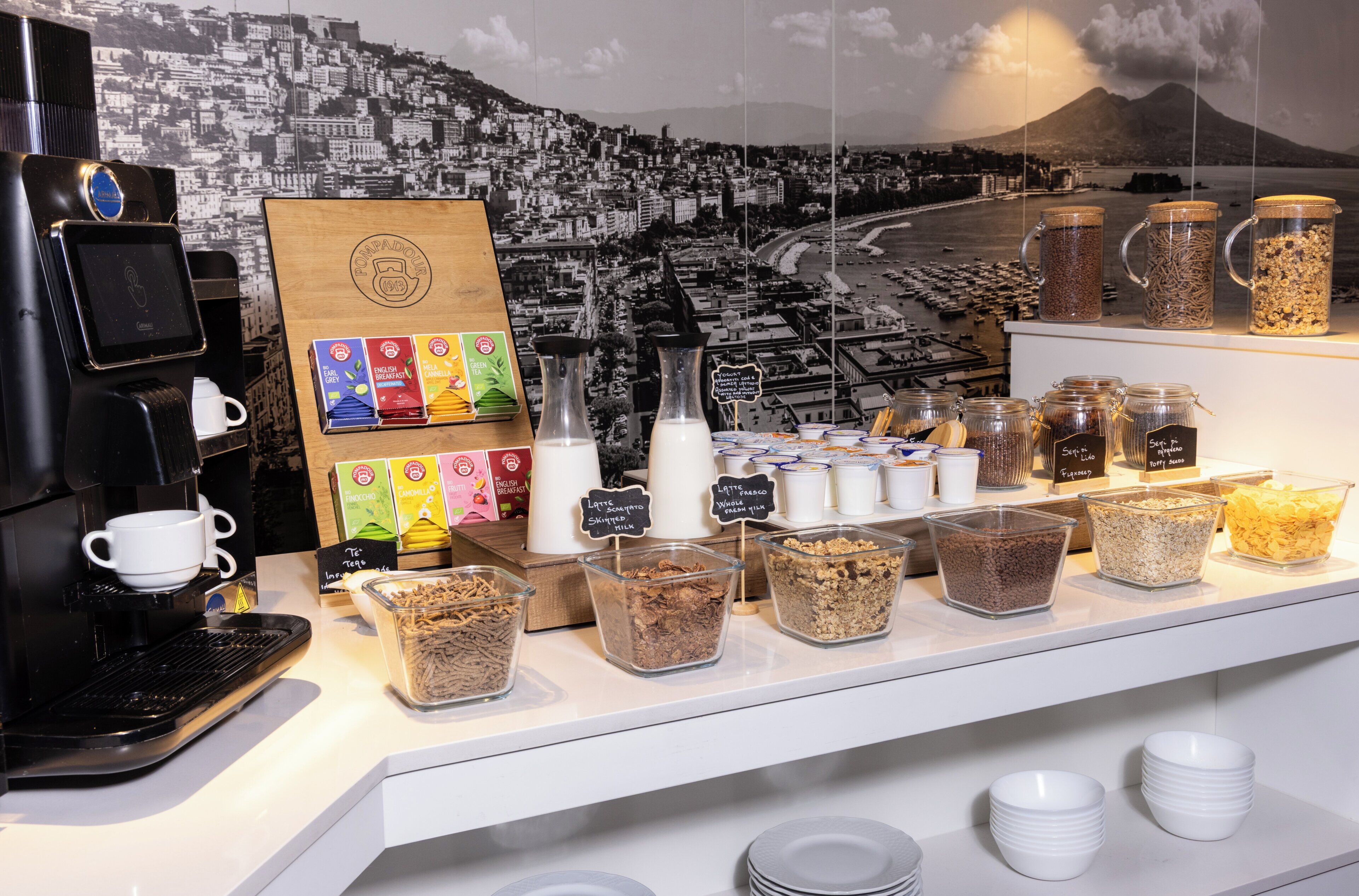 A coffee station with a coffee machine, various coffee pods, and containers of coffee grounds.