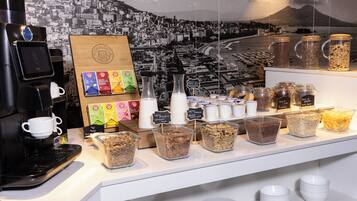 Uma estação de café com máquina de café, diversos pods de café e recipientes de pó de café.