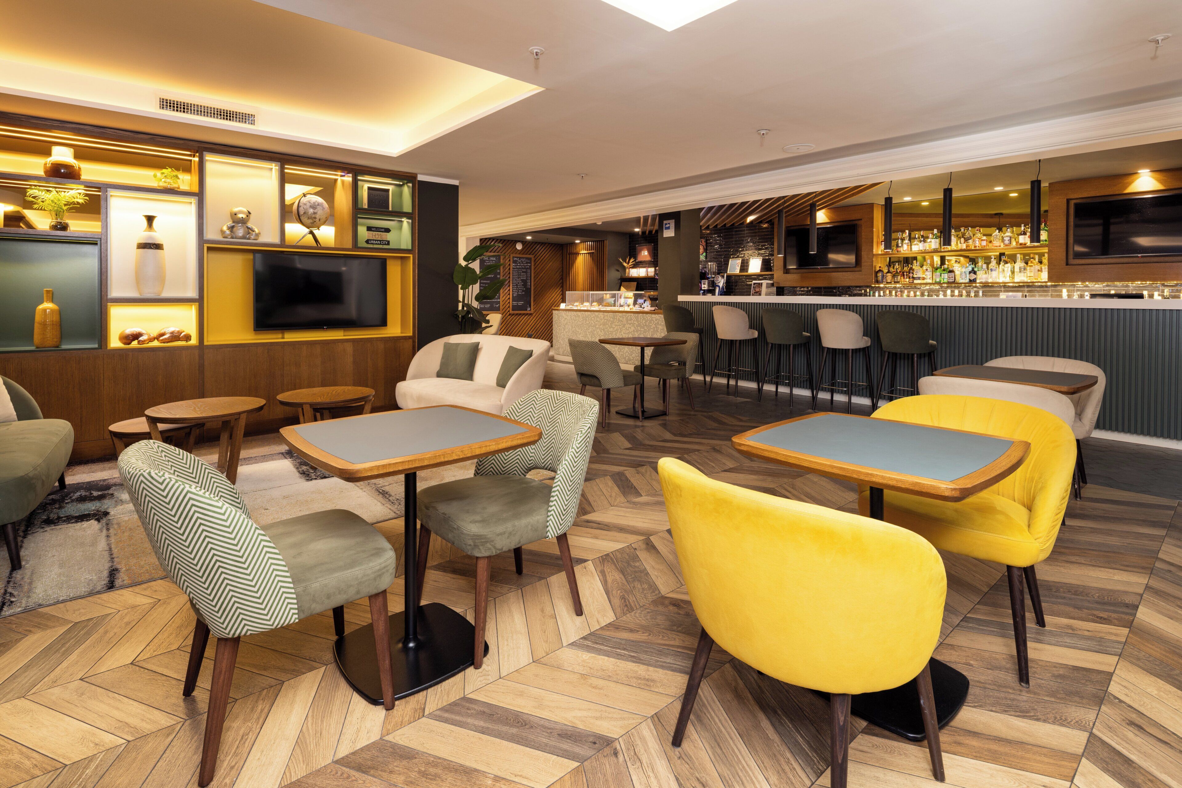 A bar area with multiple seating options, a television, and a bar counter.