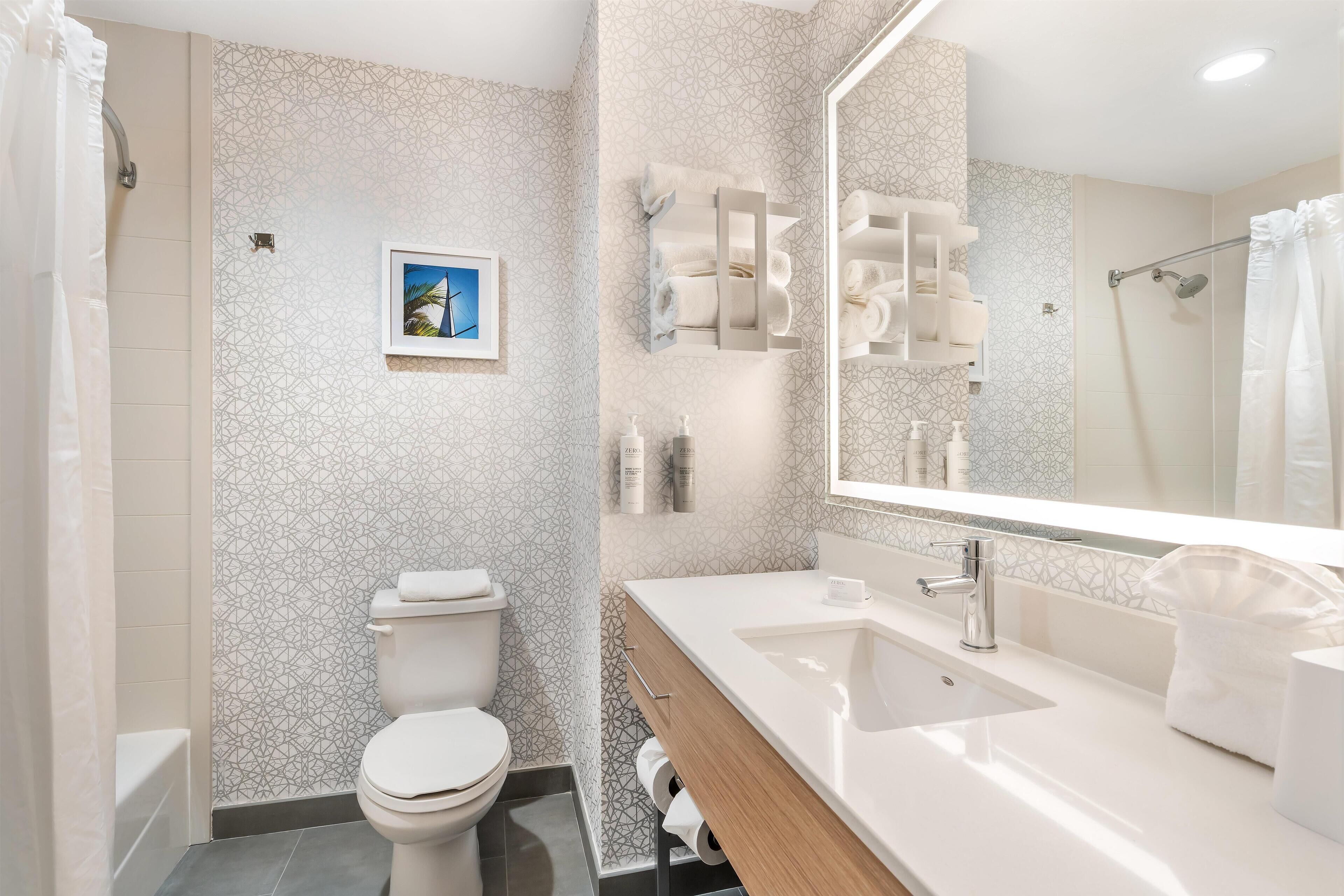 A modern bathroom with a toilet, sink, and shower.