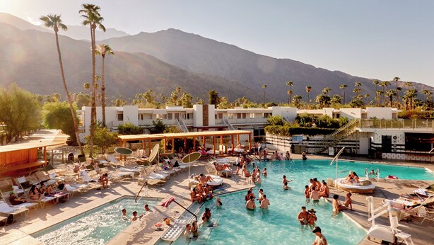 A pool area with multiple levels of sunbathing spots and a view of mountains in the background. - Ace Hotel & Swim Club Palm Springs (Palm Springs)