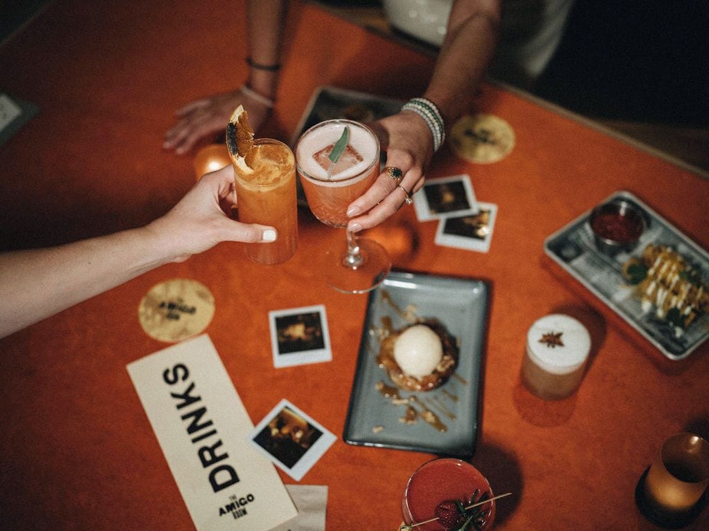 A table with drinks and a menu titled "DRINKS" at a restaurant.