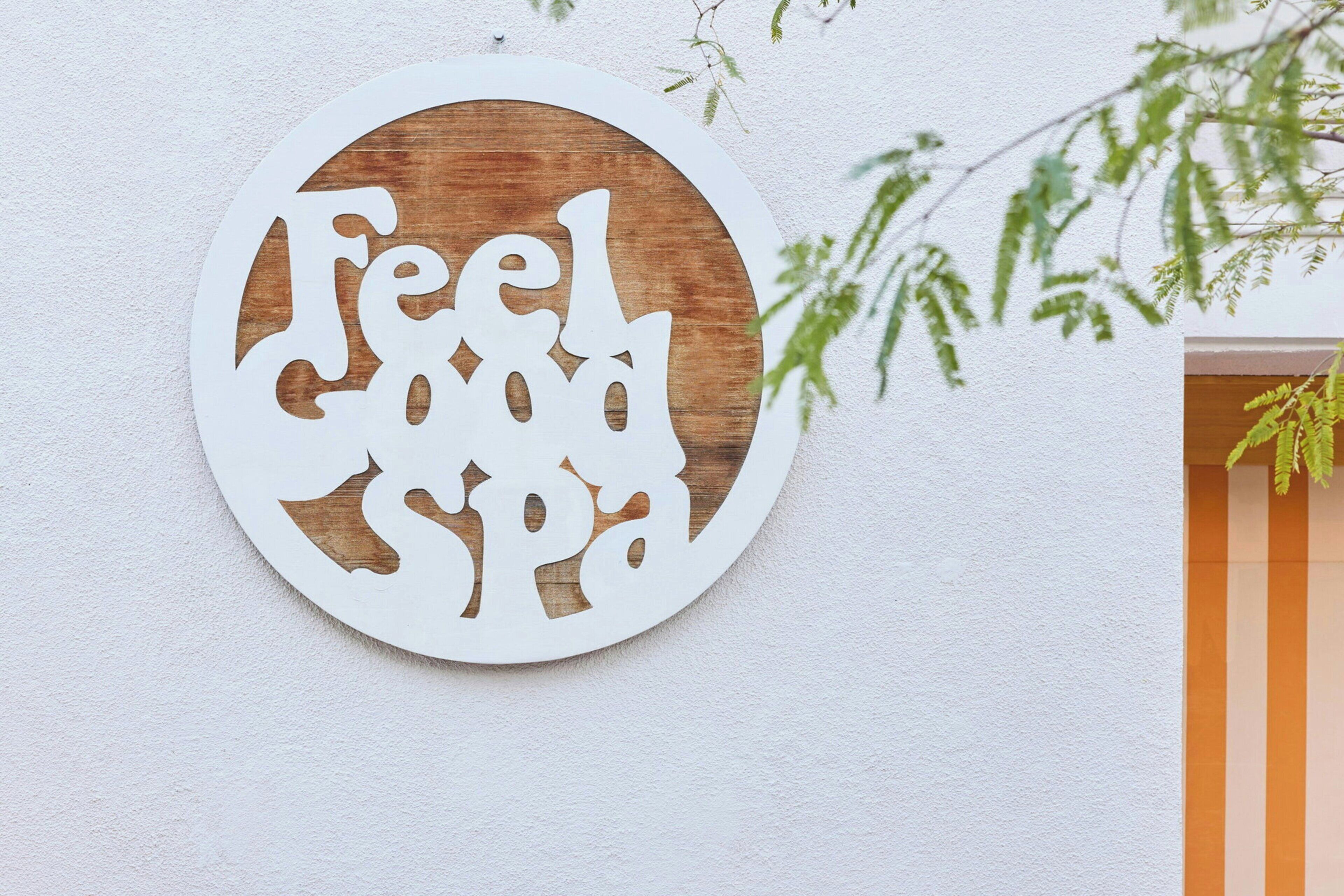 A circular wall decoration with the text 'Feel Good Spa' cut out in a stylized font.