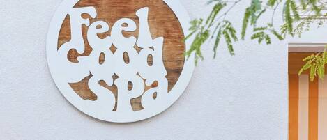A circular wall decoration with the text 'Feel Good Spa' cut out in a stylized font.
