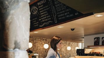 A person standing at a counter with a menu listing pastries and beverages.