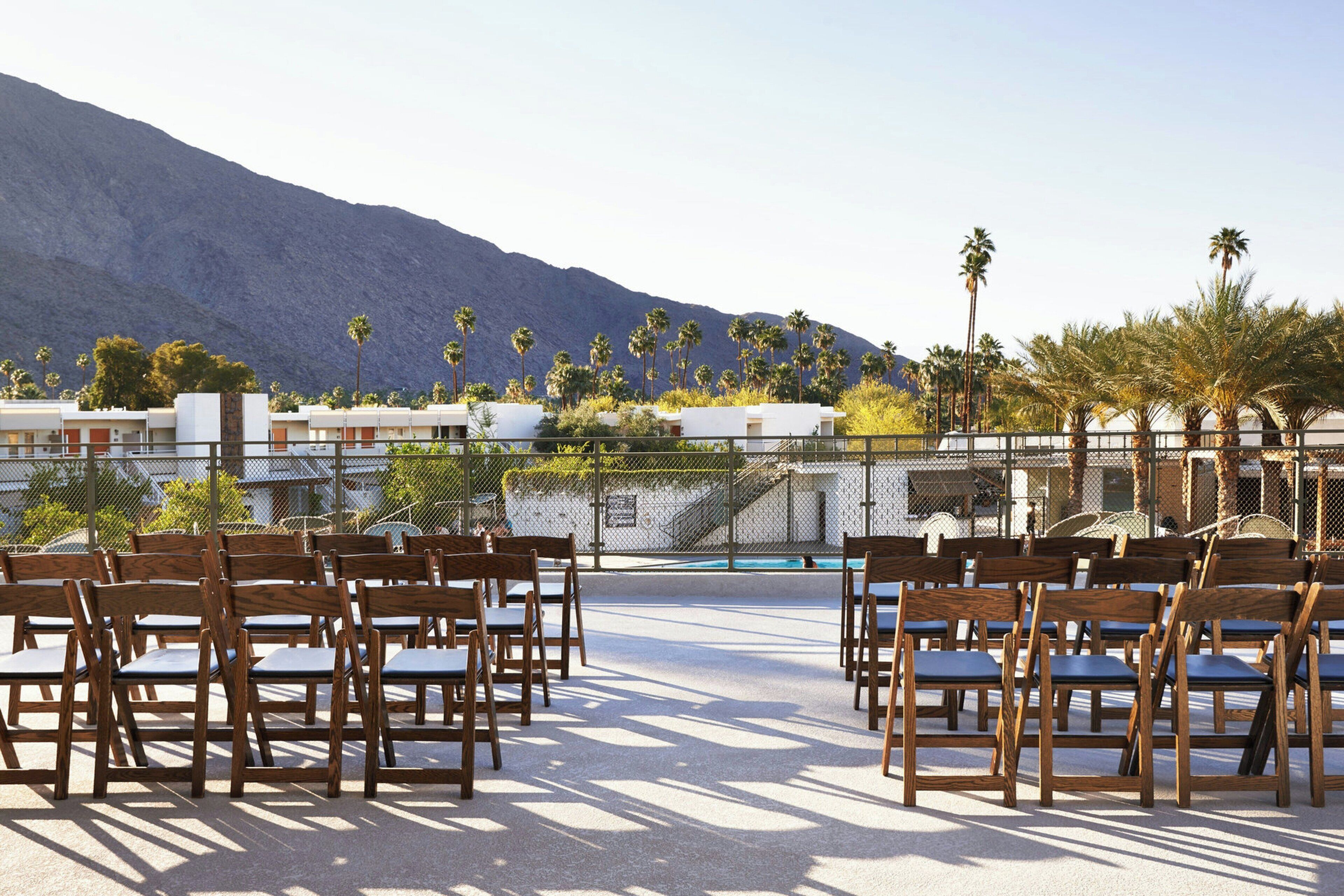 Outdoor seating with a view of a mountain and palm trees.