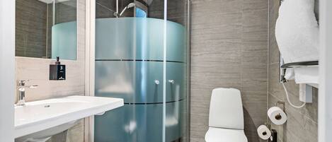 A modern bathroom with a sink, toilet, and shower.