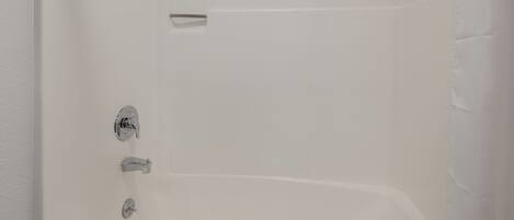 A white bathtub with chrome fixtures.