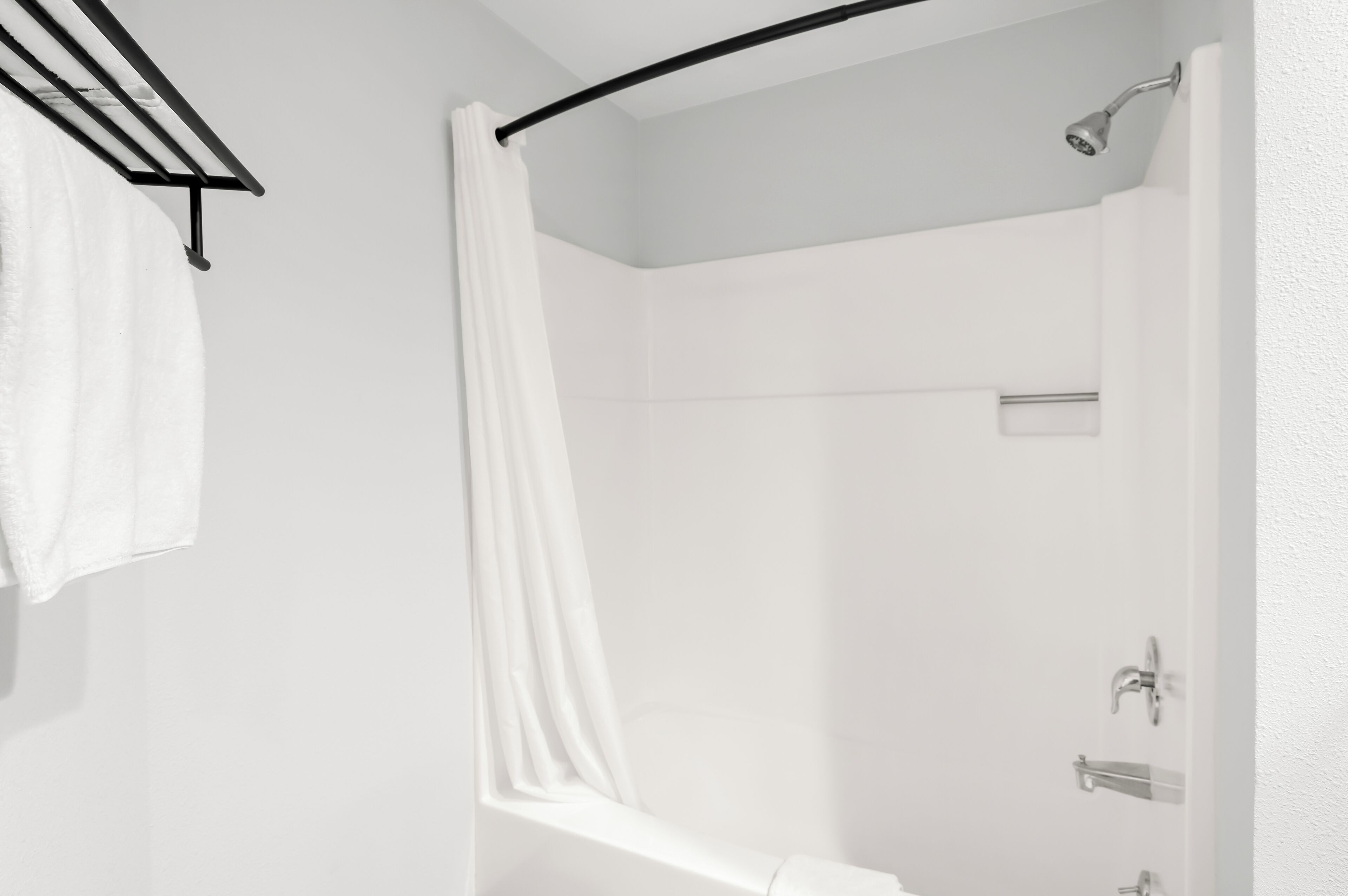 Un baño moderno con ducha, toallero y retrete.