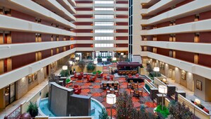 A multi-level hotel atrium with a central courtyard, multiple floors, and various seating areas.